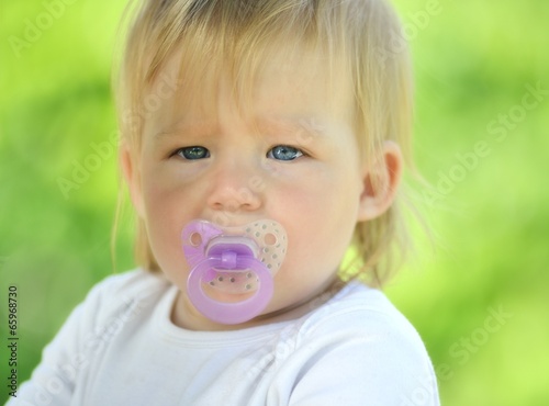 Fotografia, Obraz Cute baby with soother in his mouth, outdoors.