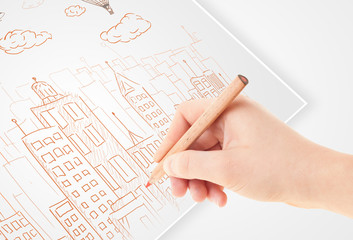 Fototapete - A person drawing sketch of a city with balloons and clouds on a
