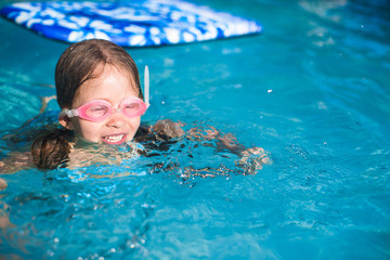 Wall Mural - Little adorable girl enjoy in the swimming pool