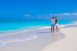 © travnikovstudio - Back view of young couple in red Santa hats on tropical sand