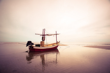 old wooden fishing boat landing on the beach, filter effect colo