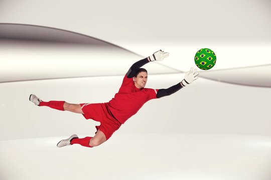 Composite image of fit goal keeper jumping up
