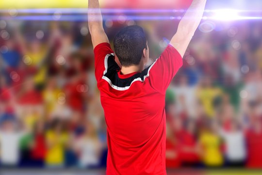 Composite image of excited football player cheering
