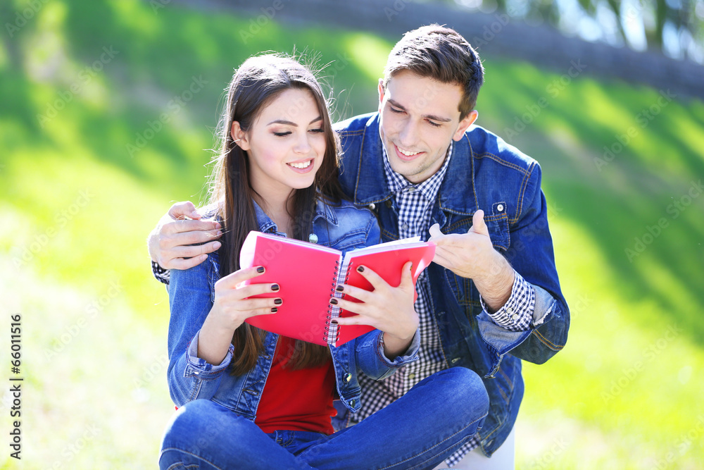 Happy students sitting in park