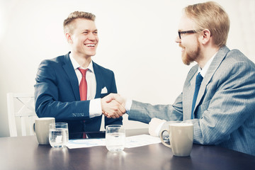 Two Sitting Men Handshaking