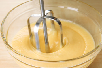 Canvas Print - Cooking, whipping eggs with electric whisk in bowl, close up