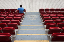 Empty Stadium Seats With A Man Alone