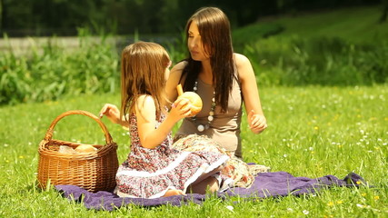 Wall Mural - Picnic. Kid and mother eating sandwiches on the meadow