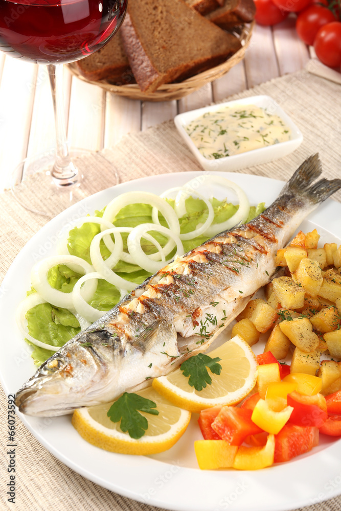 Delicious grilled fish on plate on table close-up