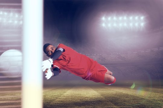 Composite image of goalkeeper in red making a save