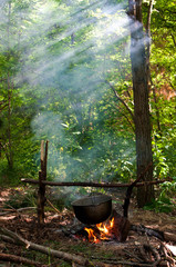 dinner cooks in a large pot over an open fire