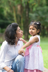 indian mother conforting her daughter in outdoor park