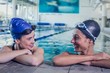 © WavebreakmediaMicro - Female swimmers smiling at each other in the swimming pool
