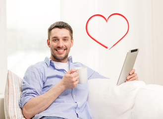 Sticker - smiling man working with tablet pc at home