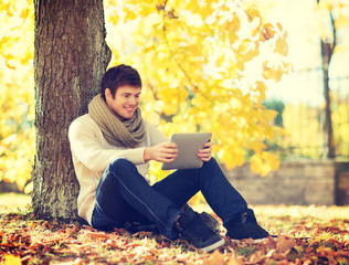 Wall Mural - man with tablet pc in autumn park