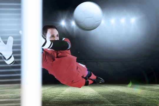 Composite image of fit goal keeper jumping up