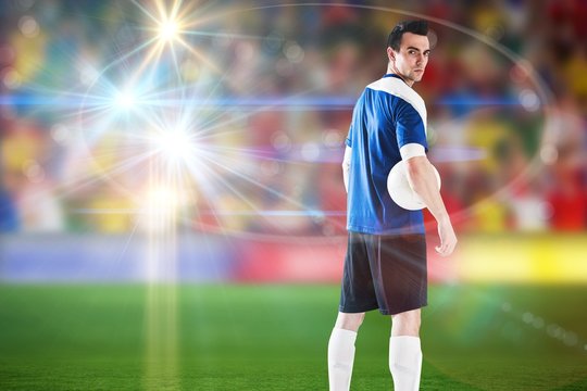 Composite image of handsome football player in blue jersey
