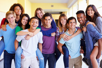 Wall Mural - Group Of High School Students Giving Piggybacks In Corridor