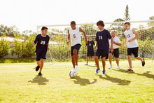 Members Of Male High School Soccer Playing Match