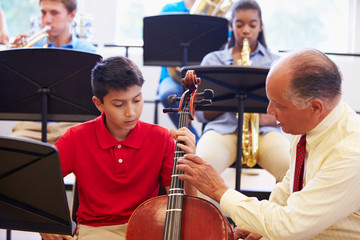 Wall Mural - boy learning to play cello in high school orchestra