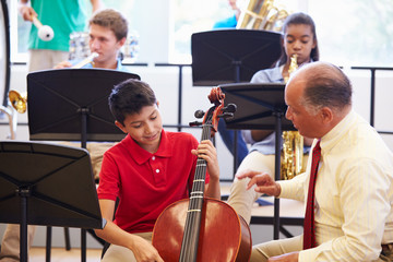 Wall Mural - boy learning to play cello in high school orchestra