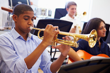 Wall Mural - male pupil playing trumpet in high school orchestra