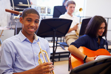 Wall Mural - male pupil playing trumpet in high school orchestra