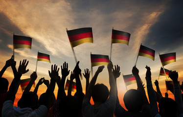 Wall Mural - Silhouettes of People Holding the Flag of Germany