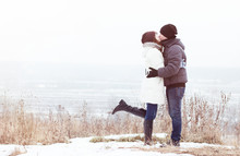 Young Couple Kissing In Nature In Winter