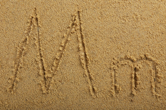 Alphabet letter written on wet beach sand