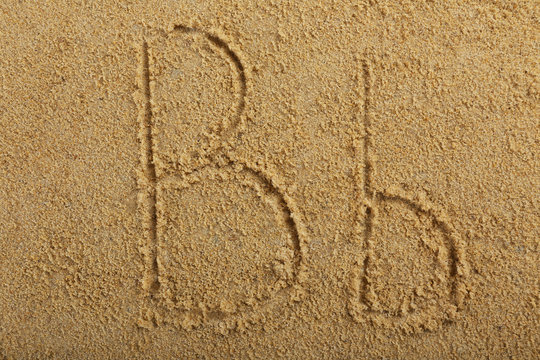 Alphabet letter written on wet beach sand