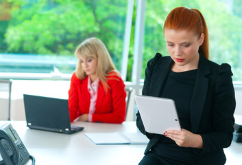 attractive business woman in office with tablet