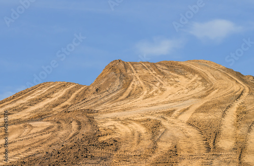 Fotografie, Obraz Construction dirt pile, tire tracks, blue sky background