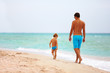 © Olesia Bilkei - father and son walking the sea beach