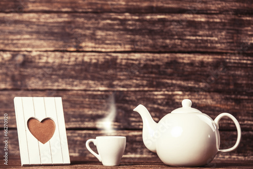 teapot-i-filizanka-kawy-z-rama-na-drewnianym-stole