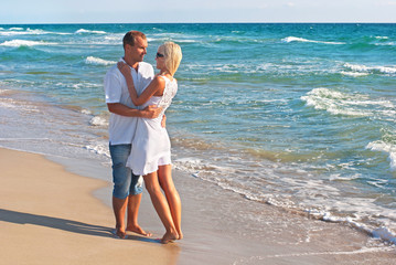 Fototapete - loving couple walking on sea beach