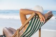 © WavebreakmediaMicro - Slim woman relaxing in deck chair on the beach