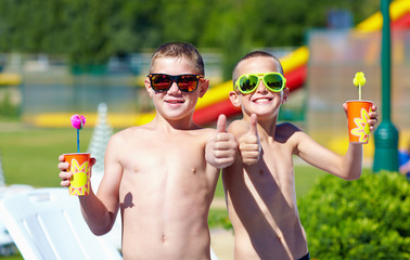 Wall Mural - happy teenage boys showing thumbs up in aquapark