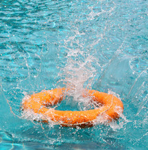 Orange Life Buoy Is Thrown To Clear Water Swimming Pool