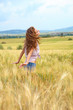 © ZoomTeam - Beautiful woman walking on the field of grain. Tuscany. italy