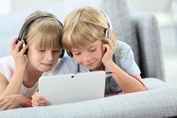 Kids listening to music on internet with tablet