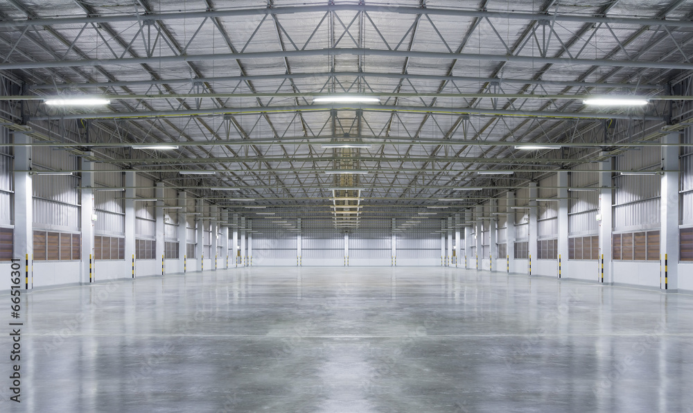Concrete floor inside industrial building. Use as large factory, warehouse, storehouse, hangar or plant. Modern interior with metal wall and steel structure with empty space for industry background. - obrazy, fototapety, plakaty 
