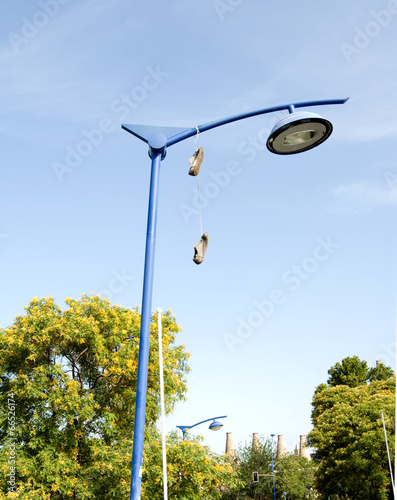 Old shoes hanging from their laces , Buy this stock photo