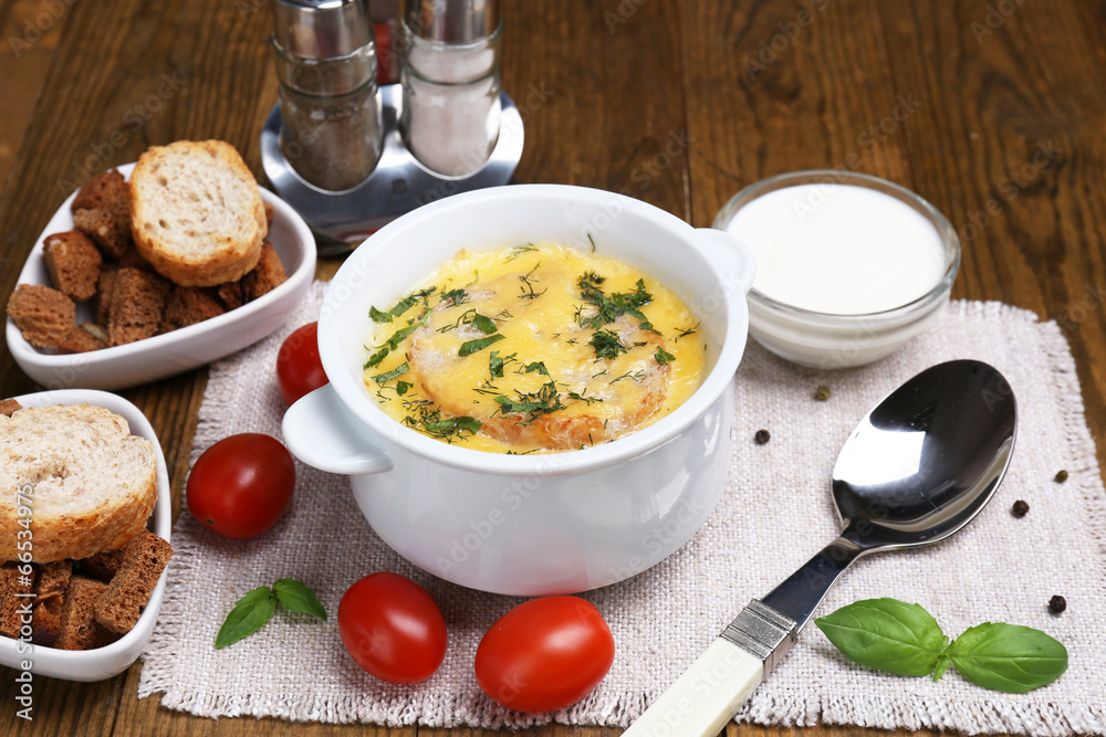 Tasty soup in saucepan on wooden table, close up