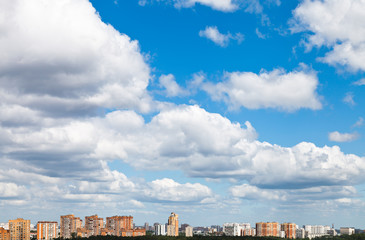 Wall Mural - many woolpack clouds over city in summer