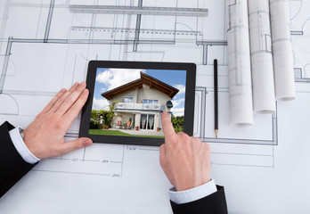 Poster - Architect Using Digital Tablet On Blueprint In Office