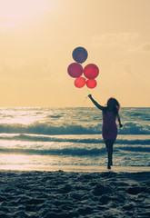 beautiful woman with colorful balloons on seaside