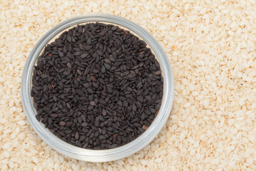 Black seed sesame in the cup on the white seed sesame background