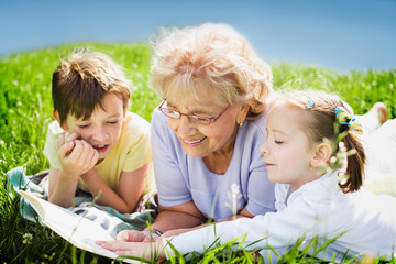 Wall Mural - grandmother reading book to grandchildren