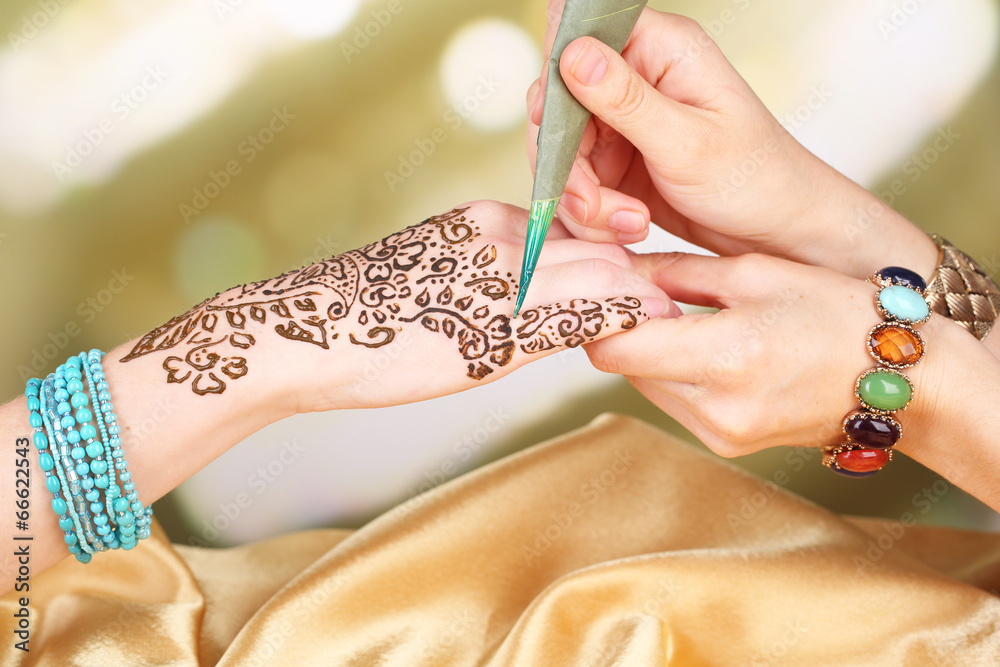Process of applying Mehndi on female hand, close up